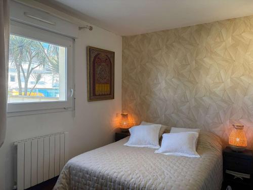 - une chambre avec un lit doté de 2 oreillers blancs et d'une fenêtre dans l'établissement Appartement 56m² bord de mer avec terrasse, parking privé, WiFi - FR-1-542-67, à Trébeurden