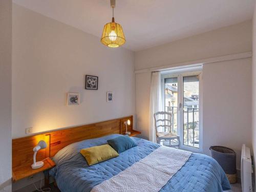 une chambre avec un lit bleu et une fenêtre dans l'établissement Appartement T2bis 4-6 pers à Cauterets, proche centre thermal - FR-1-234-335, à Cauterets