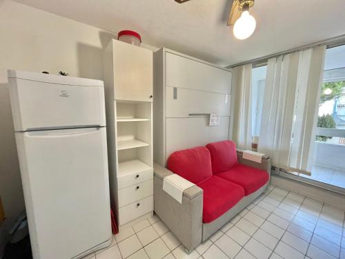 - un salon avec un canapé rouge et un réfrigérateur dans l'établissement Studio cabine près des plages avec garage privé - 4 pers - FR-1-716-83, au Grau-du-Roi