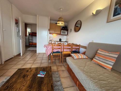 un salon avec un canapé et une table dans l'établissement Charmant appartement avec terrasse dans résidence avec piscine à Ciboure - FR-1-239-1107, à Ciboure