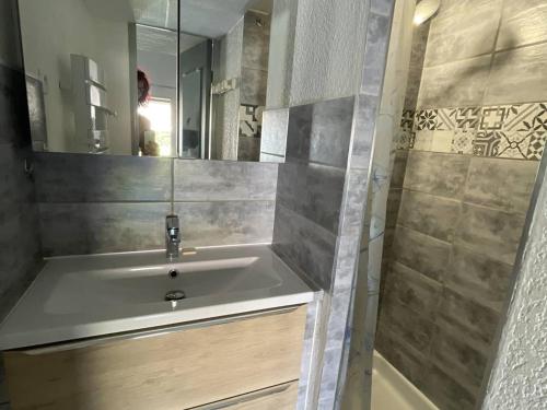 une salle de bain avec un lavabo, un miroir et une douche dans l'établissement Villa climatisée proche plage avec piscine et parking - FR-1-723-175, au Cap d'Agde
