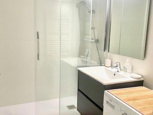 une salle de bain blanche avec une douche et un lavabo dans l'établissement Charmant studio 3* avec balcon et wifi proche des thermes - FR-1-703-210, à Amélie-les-Bains-Palalda