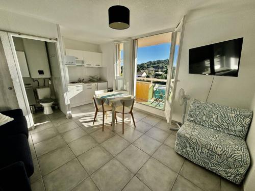 un salon avec une table et un canapé dans l'établissement Appartement lumineux avec terrasse et parking proche plage - FR-1-816-27, à Bormes-les-Mimosas