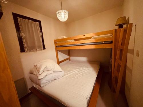Cette petite chambre comprend des lits superposés avec des draps blancs. dans l'établissement Appartement cosy à Autrans, animaux admis, parking, 4 pers - FR-1-737-94, à Autrans
