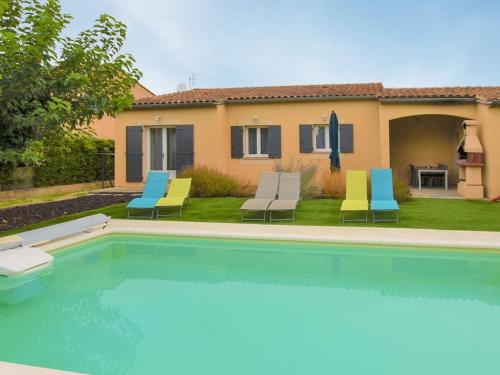 une piscine avec des chaises et une maison dans l'établissement Villa agréable près d'Avignon avec piscine privative et WiFi - FR-1-708-85, à Avignon