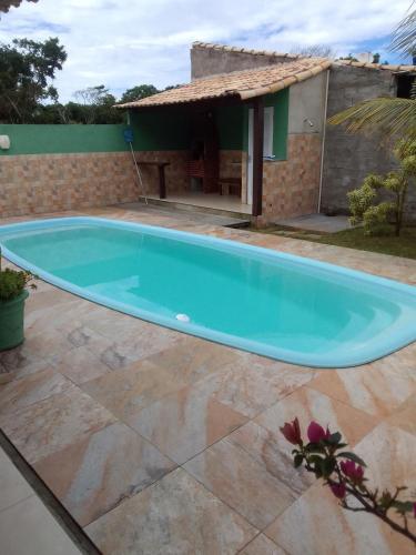 a large blue swimming pool in front of a house at Casa aconchego in Búzios
