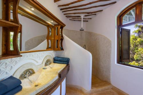 a bathroom with a sink and a window at Fig House in Takaungu