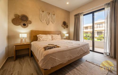 a bedroom with a bed and a large window at Xunik Tulum 205 1BR Condo in Tulum
