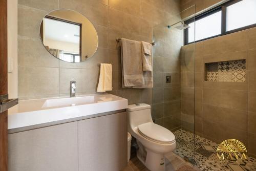 a bathroom with a toilet and a sink and a mirror at Xunik Tulum 205 1BR Condo in Tulum