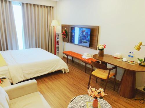 a hotel room with a bed and a desk and a table at Homestay Apec Mandala Hotel & Suites Hai Duong in Hải Dương