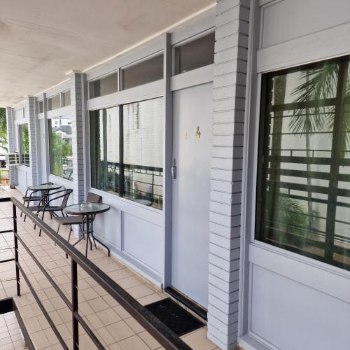 a balcony with windows and a table and chairs at A1 Inn the city A1 Car Rentals in Cairns