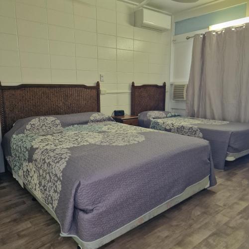 two beds sitting in a room withermottermottermott at A1 Inn the city A1 Car Rentals in Cairns