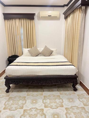 a bedroom with a large bed with curtains at Luang Prabang Bakery & Guest House in Luang Prabang