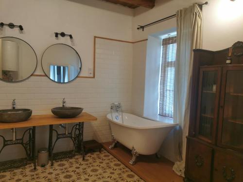 a bathroom with two sinks and a bath tub at Lelle Cottage in Balatonlelle