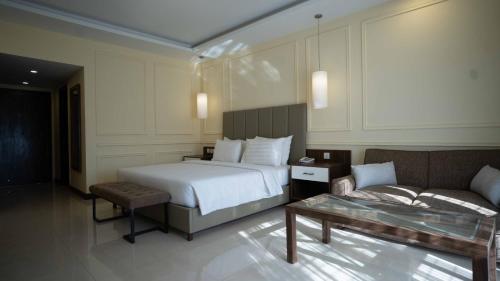 a hotel room with a bed and a couch at Arbian Sea Country Club in Karachi