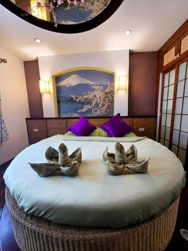 a bedroom with a large bed with two bowls on it at Lamduan Boutique Homestay in Chiang Mai
