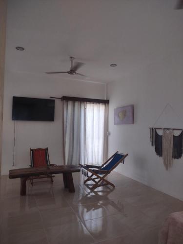 a living room with a chair and a bench and a television at Casita viento in El Cuyo