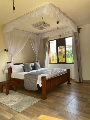a bedroom with a large bed with a canopy at Almond 7 in Gazi
