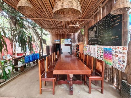 a dining room with a wooden table and chairs at Ratanakiri Homestay & Jungle Trek in Banlung