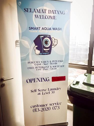 a sign for a washing machine with a camera on it at Riveria City by Nomadnest in Kuala Lumpur