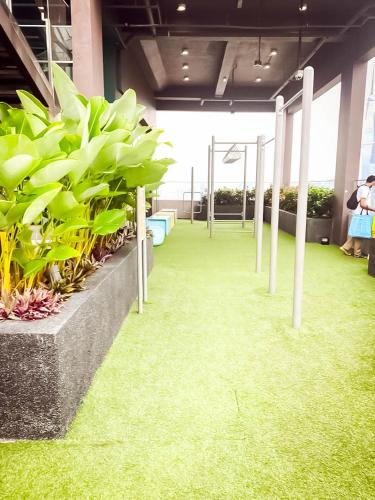 a room with green grass and plants and poles at Riveria City by Nomadnest in Kuala Lumpur