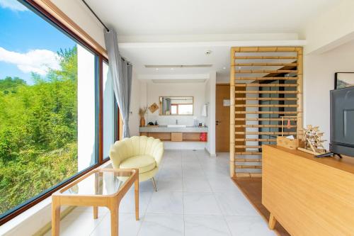 a living room with a tv and a window at Anji Bamboo Homestay in Tangkou