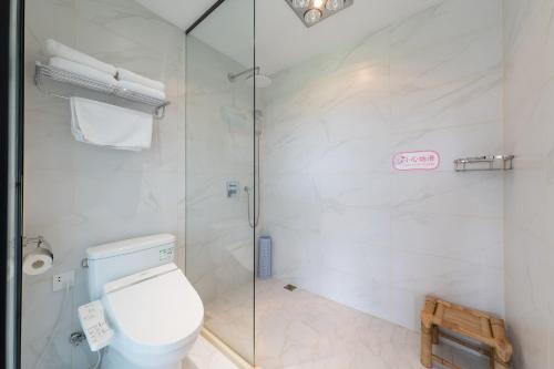 a bathroom with a toilet and a glass shower at Anji Bamboo Homestay in Tangkou