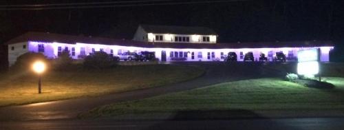 a lit up building at night with a street light at Mount Blue Motel in Farmington