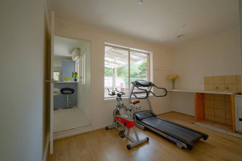 a room with a gym with a treadmill and a window at Devon Meadows Farm Escape in Devon Meadows