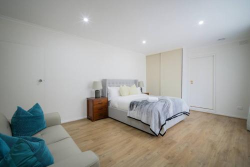a white bedroom with a bed and a couch at Devon Meadows Farm Escape in Devon Meadows