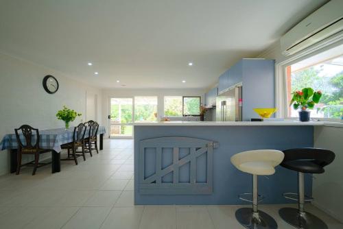 a kitchen with a counter with chairs and a table at Devon Meadows Farm Escape in Devon Meadows