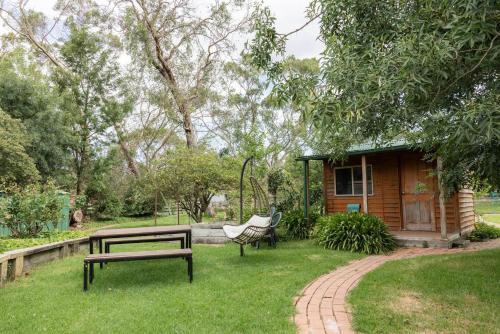 a picnic table and bench in front of a cabin at Devon Meadows Farm Escape in Devon Meadows