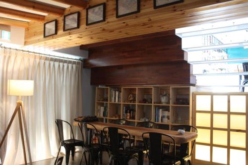 a room with a table and chairs and a book shelf at Andong Poong-gyung HOSTEL n LIBRARY in Andong