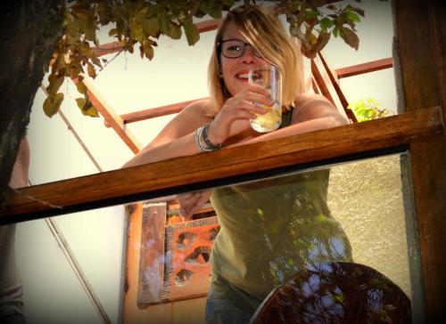 a woman drinking a glass of wine in front of a mirror at Hospedaje Turistico Recoleta in Cusco