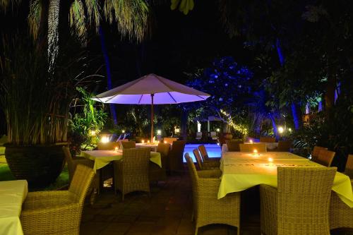 a restaurant with tables and chairs and an umbrella at Villa Boreh Beach Resort and Spa in Tejakula