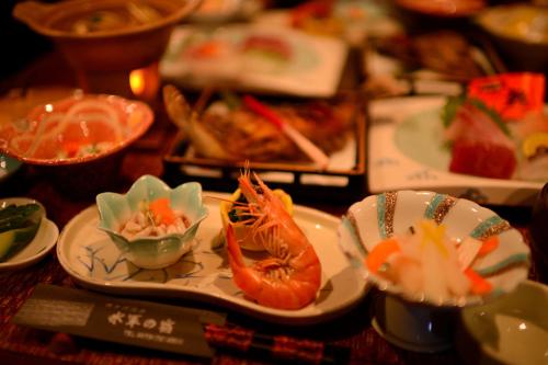 a table topped with plates of food with sushi at Suigunnoyado in Ajigasawa