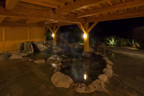 a pond under a wooden pavilion at night at Hotel Izukyu in Shimoda