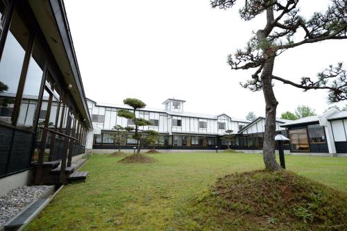 a building with a tree in front of it at Suigunnoyado in Ajigasawa