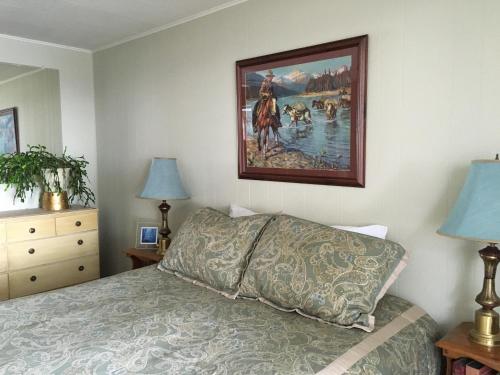 Sagle的住宿－Sleep's Cabins，卧室配有一张床,墙上挂有绘画作品