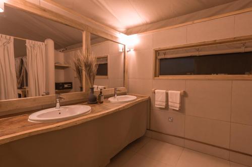 a bathroom with two sinks and a mirror at MAISHA SWEETWATERS CAMP in Ol Pejeta Conservancy