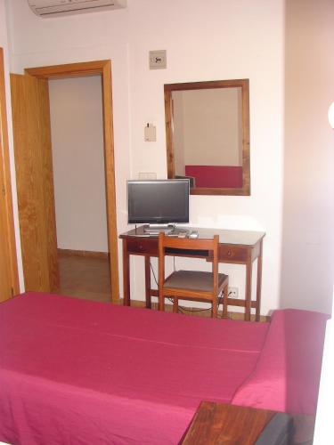 a bedroom with a desk with a computer on it at Hostal Talamanca in Talamanca