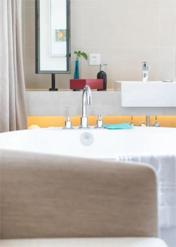 a bathroom with a sink and a mirror at SSAW Boutique Hotel Sanya in Sanya