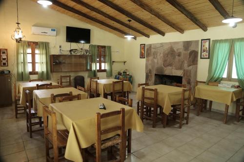 un restaurante con mesas y sillas y una chimenea en Complejo Los Parrales en General Alvear