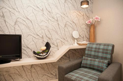 a living room with a tv and a chair at Yesday B&B in Dongshan