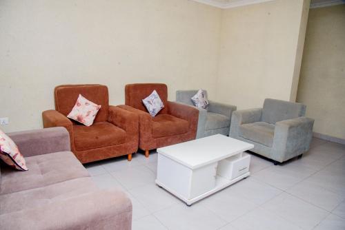 a living room with two couches and two chairs at Airport Style inn Apartment in Kigali