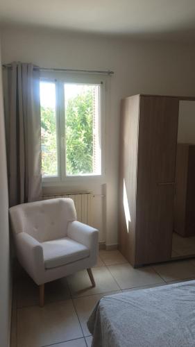 a living room with a chair and a window at Villa Lina 6 pers plages et rivières in Prunelli-di-Fiumorbo