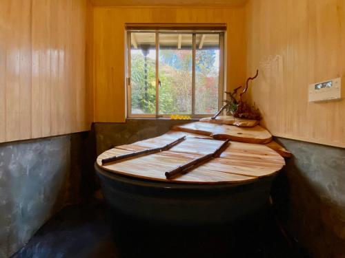 a wooden tub in a room with a window at Minshuku Murou in Uda