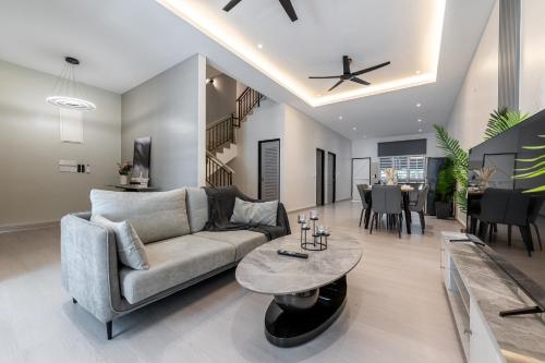 a living room with a couch and a table at La Ferringhi Villa - 5 Bedroom Bungalows by ALV in Batu Ferringhi
