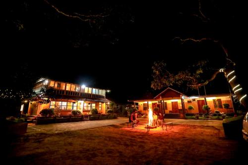 a group of people standing outside a building at night at Swasta Homestays Wayanad in Kaniyāmbetta