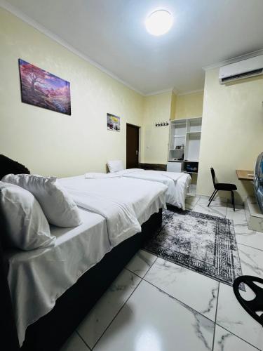 a bedroom with two beds and a table and chairs at Kitty Guest House in Bellville